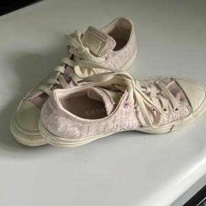 Pink low top Converse sneakers.